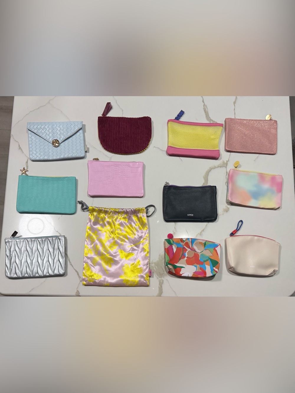 Collection of twelve colorful, assorted Ipsy cosmetic bags and pouches